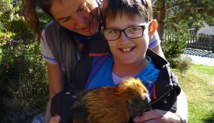 Bäuerin Anita Steinringer und Aaron mit einem japanischen Seidenhuhn Bäuerin Anita Steinringer und Aaron mit einem japanischen Seidenhuhn